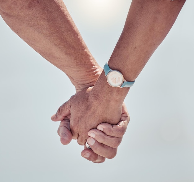 Foto coppia che si tiene per mano con amore su sfondo all'aperto per relazione di cura o sostegno matrimoniale primo piano mano di uomo donna e persone che camminano nella natura vacanza e relax insieme alla data del partner