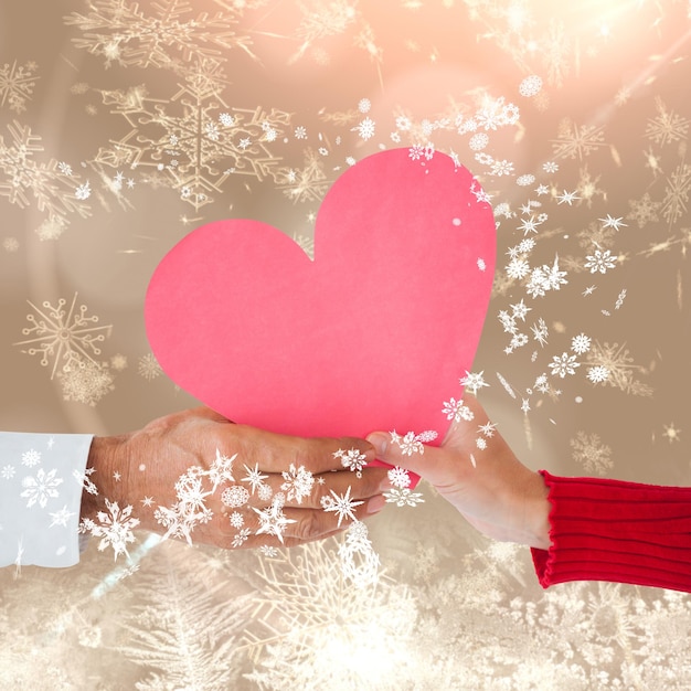 Couple holding heart against cream snow flake pattern design