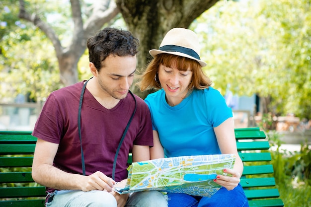 Couple holding map in hands and traveling together.