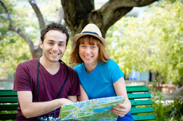 Couple holding map in hands and traveling together.