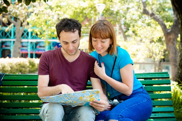 Couple holding map in hands and traveling together.