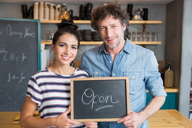 Couple holding open signboard