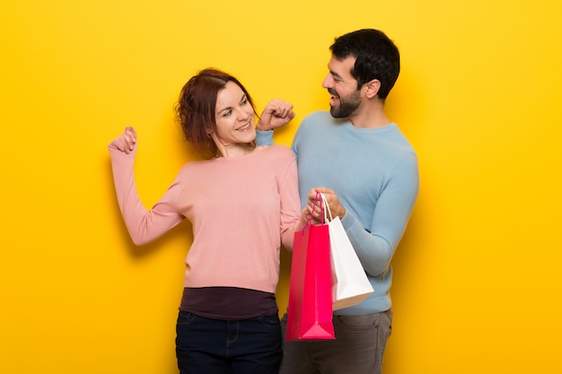 Couple holding shopping bags in victory position