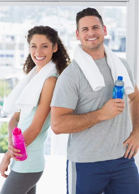 Couple holding water bottles at gym