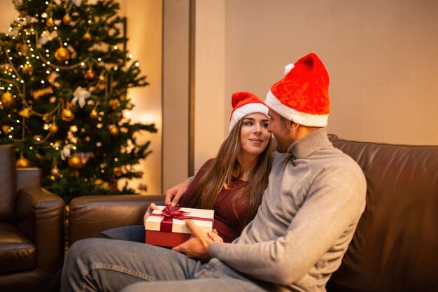 Couple at home for Christmas with gits and an Xmas tree