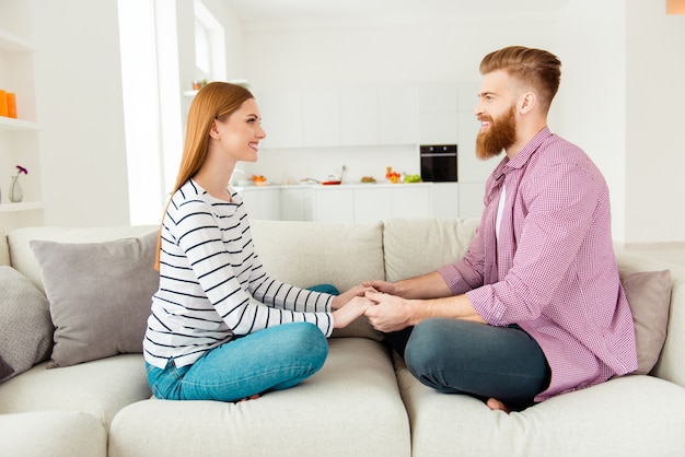 Couple at home on sofa holding hands