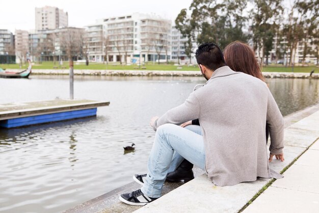 Couple hugging each other close to a lake