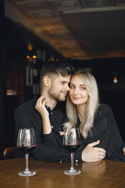 Couple hugging and have wine in cafe