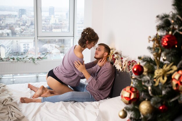 クリスマスの時期にお互いに家で抱き合っているカップル