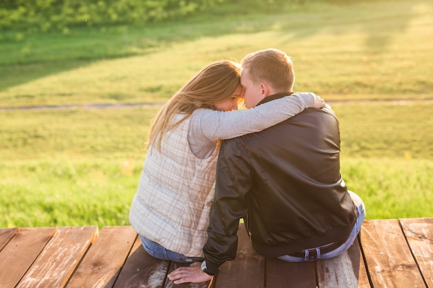 Couple hugging on a pier in nature back view