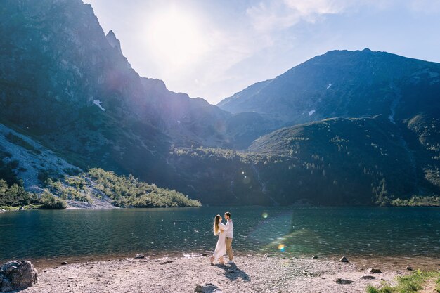 Couple hugging on the shore of a beautiful lake