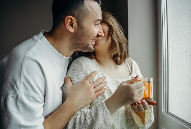 Photo couple hugs beside he window