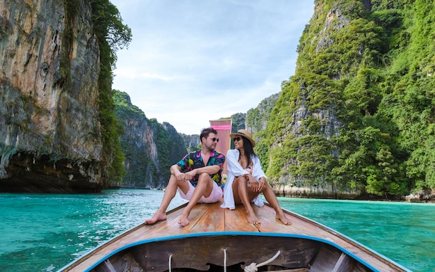 Фото Пара перед длиннохвостой лодкой в лагуне острова пхи-пхи, таиланд