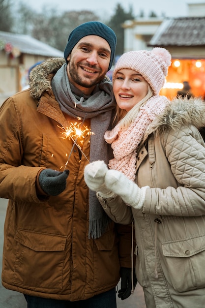 写真 花火の輝きを保持している冬の男のカップル