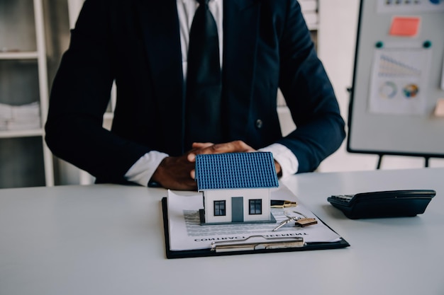 Photo a couple is approaching a housing project to buy and they are discussing details and advice with a salesperson in a housing project real estate trading ideas with couples