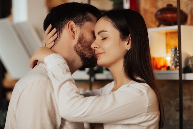 Couple is embracing in the living room.