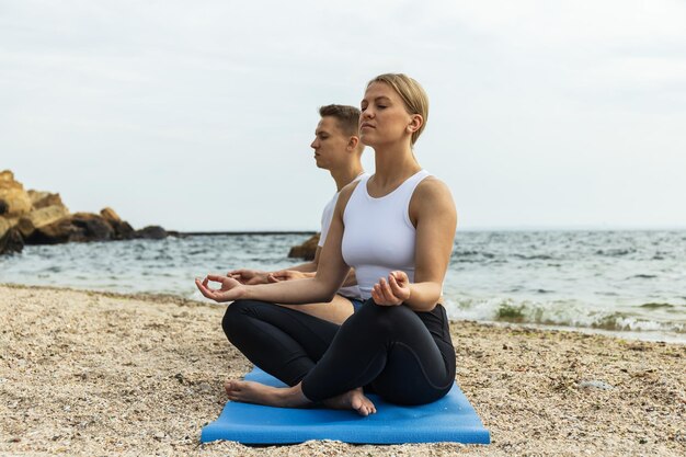 A couple is meditating on the seashore