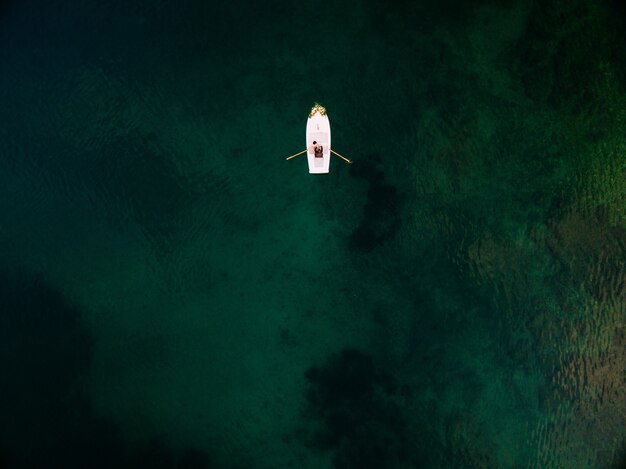 Couple is sailing on a boat on the sea aerial view