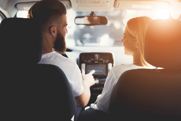 Couple is sitting in comfortable modern electric car.