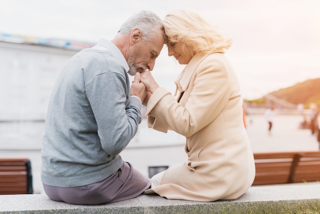 Couple is sitting on the edge of a flower bed