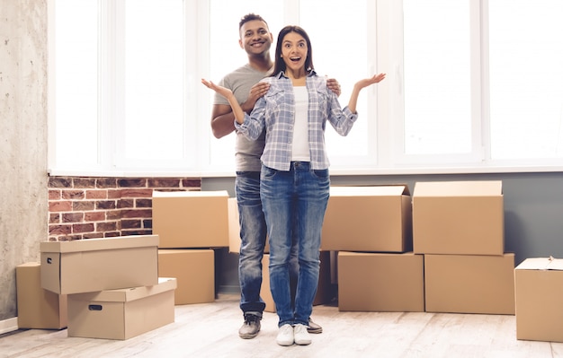 Couple is smiling while standing near the packed boxes