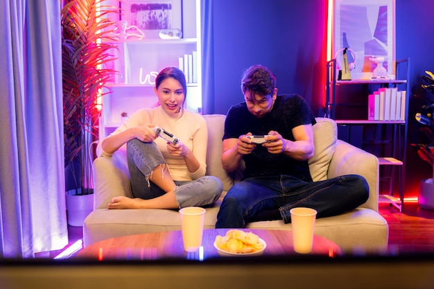 couple joyful funny playing game using joysticks trying to disturb postulate