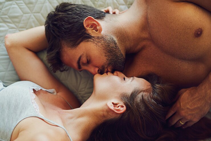 Photo couple kiss and relax with bed above for affection intimacy or love for bonding support or care at home top view of man woman or lovers lying in bedroom together embrace or compassion at house