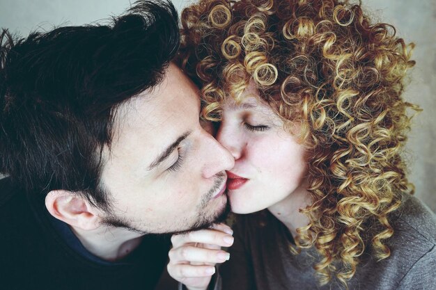 Photo couple kissing against wall