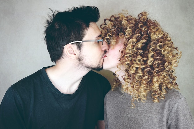 Photo couple kissing against wall