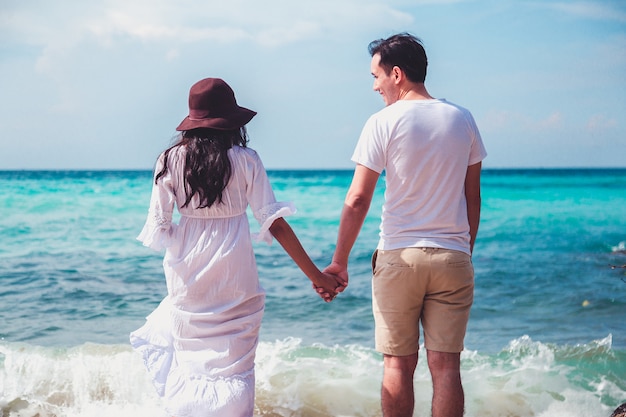 Couple kissing on the beach with a beautiful sunset in background.