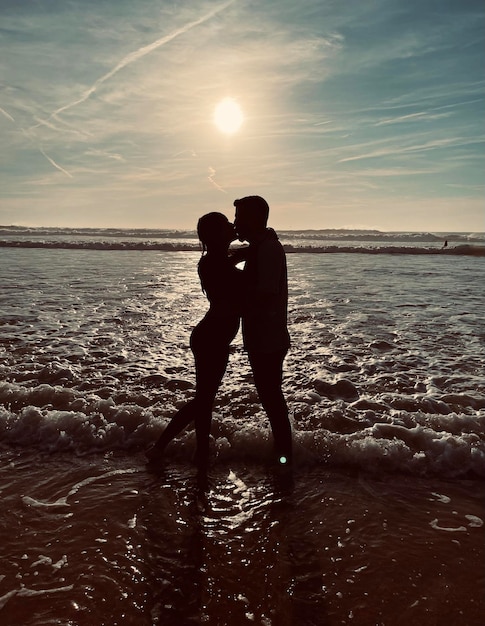 Foto coppia baciarsi sulla spiaggia