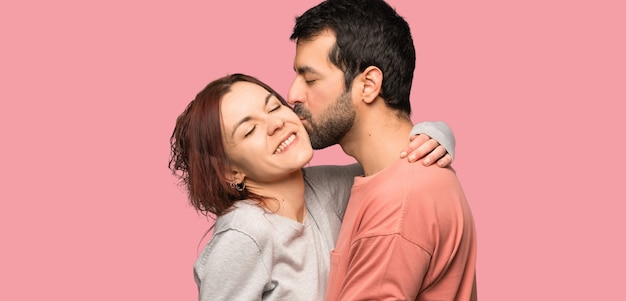 Couple kissing over isolated pink background