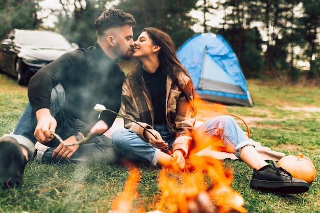 Couple kissing near campfire