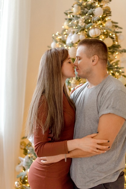 Couple kissing near a Christmas tree