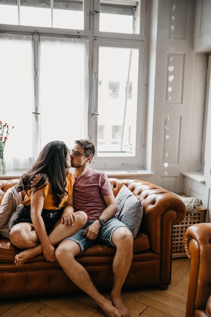 Photo couple kissing on sofa at home