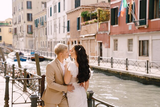 Foto coppia che si bacia in piedi vicino al canale