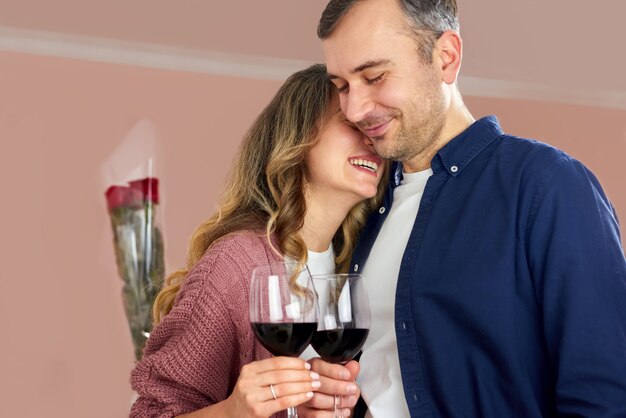 A couple at the kitchen drinking red wine