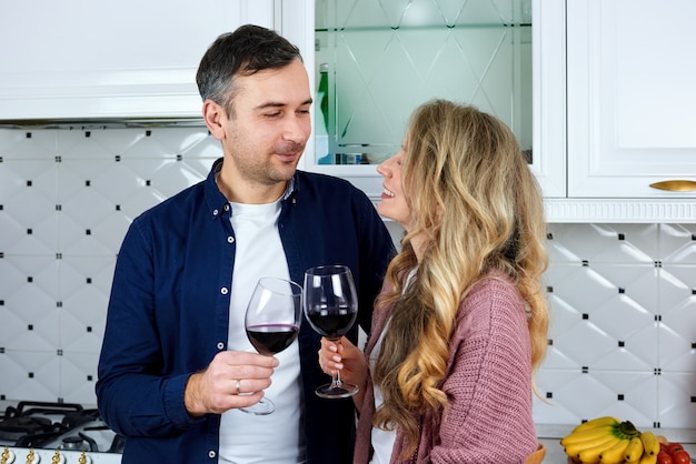 A couple at the kitchen drinking red wine