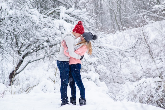 Couple in knitted hats going to kiss