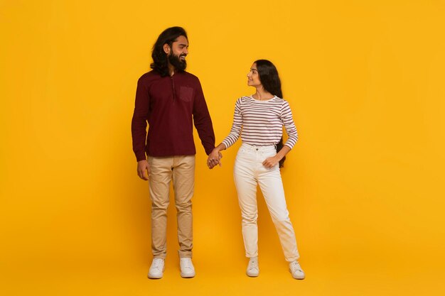 Photo couple laughing together on yellow background