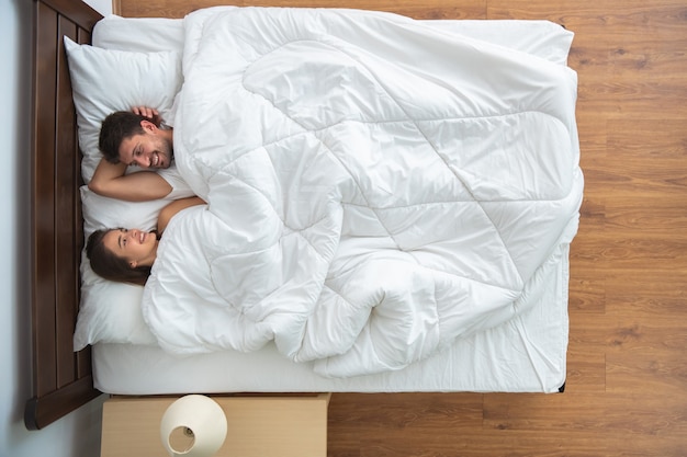 The couple laying on the bed. view from above