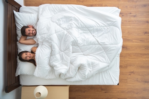 The couple laying on the bed. view from above