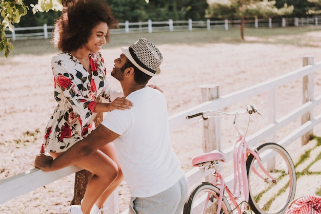 Couple Lean On Race Track Fence Bike Ride