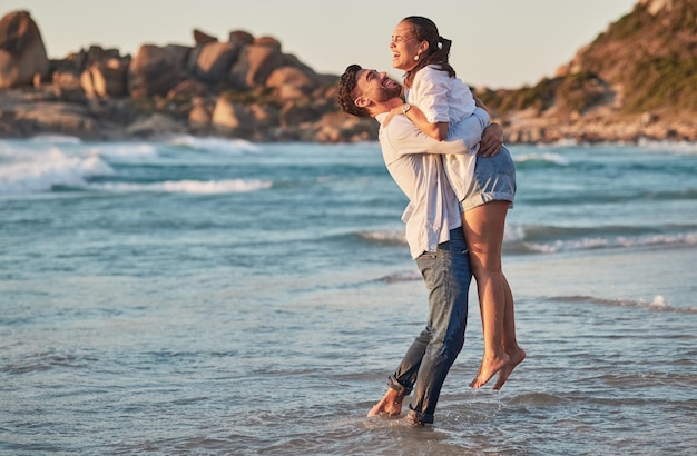 Couple lift and hug at beach celebrate dating love care and trust on ocean summer travel or Bali vacation Excited man and woman happy smile and happiness together enjoy romantic Hawaii sea holiday