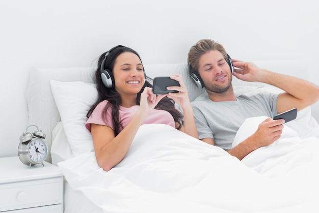 Coppia ascoltando musica nel loro letto