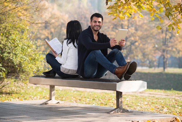 Couple Look At A Digtial Tablet And Book