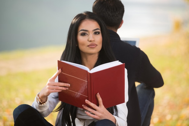 Couple Look At A Digtial Tablet And Book