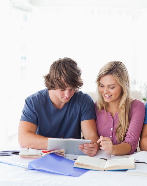 A couple look at a tablet together while smiling