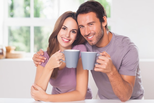 Couple looking at the camera with a coffee