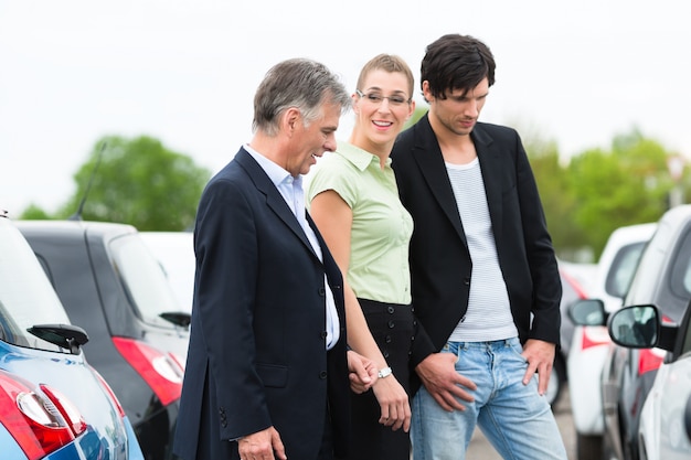 Couple looking at car on yard of dealer